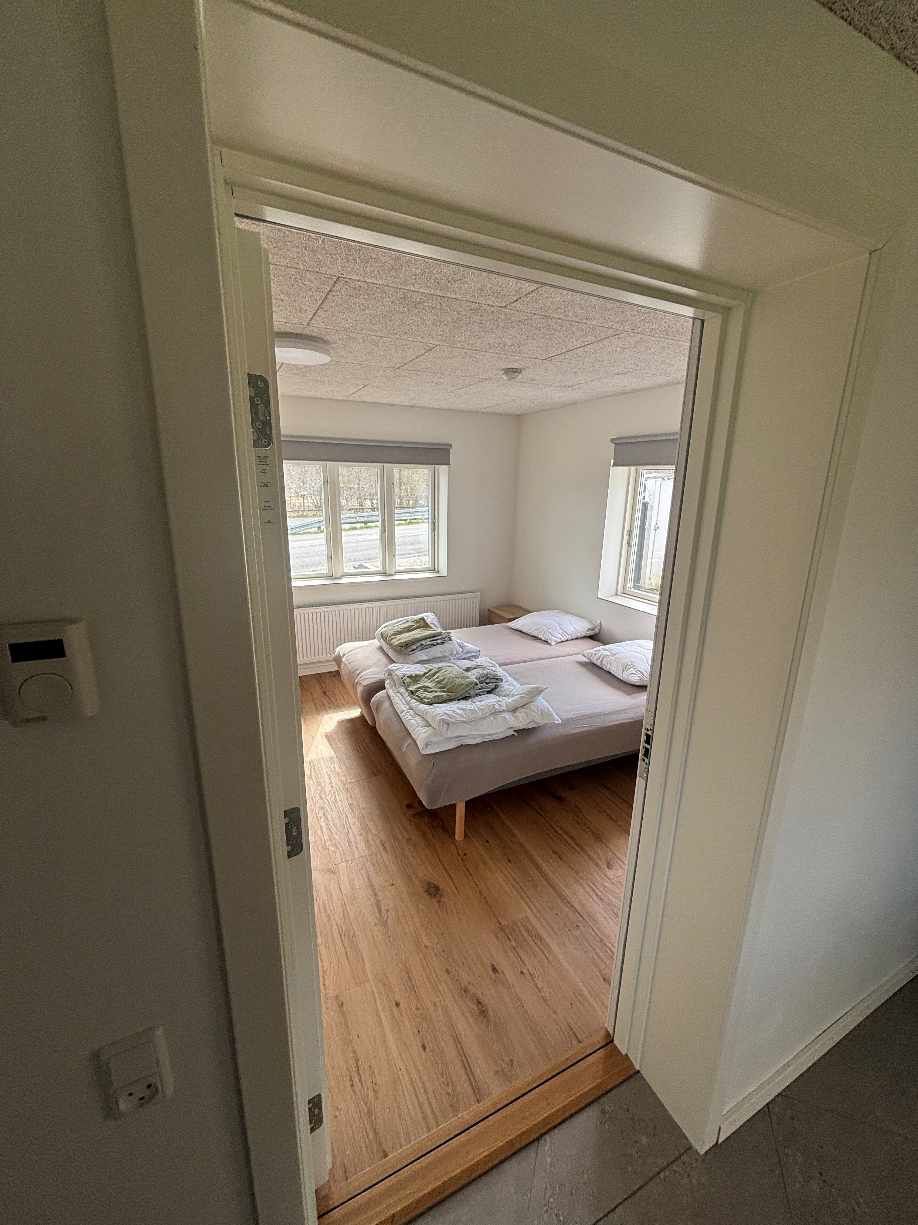 Eight shirts arranged on table in black, olive, grey, blue, white, red, mustard, and green.