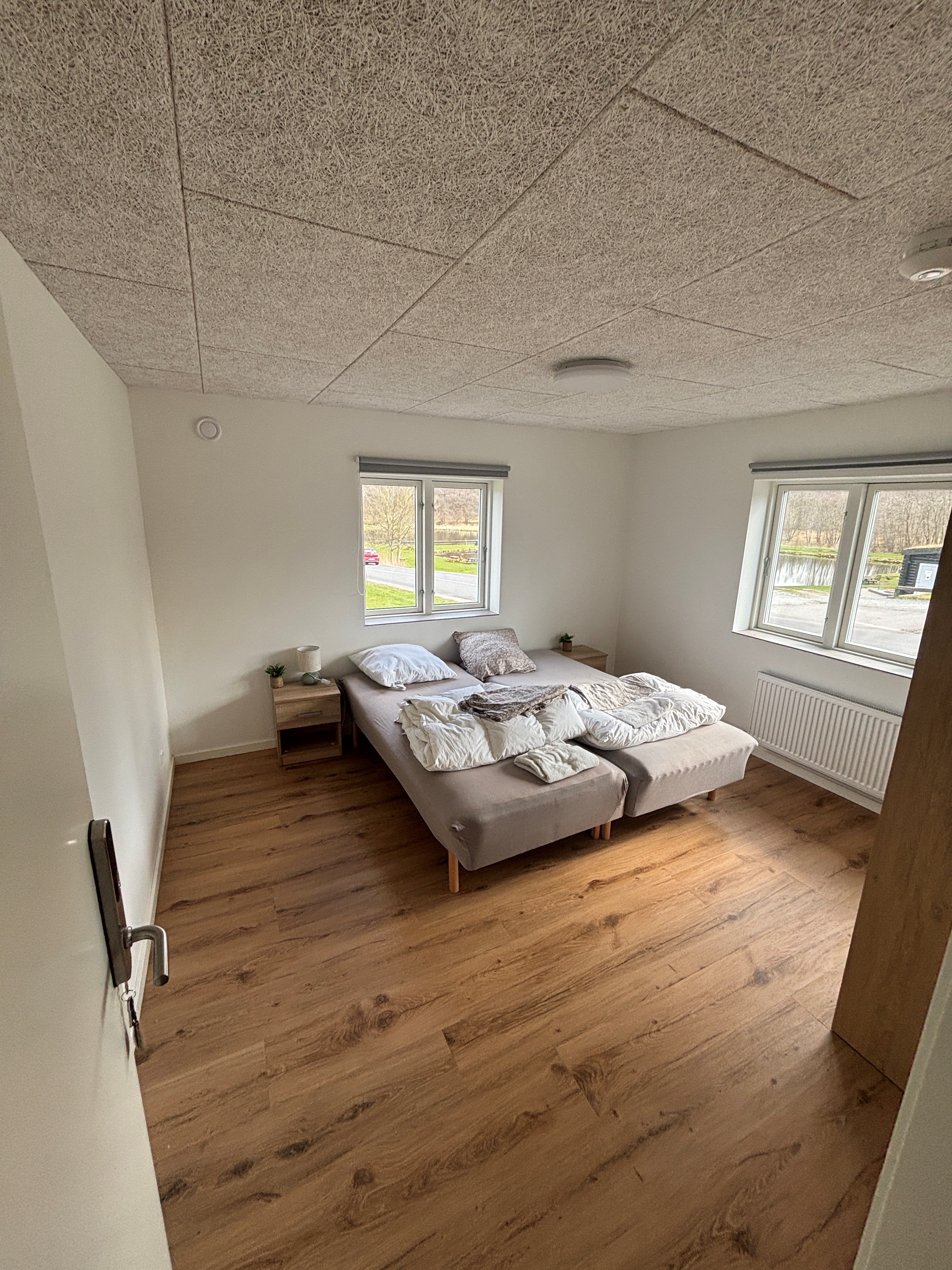 Eight shirts arranged on table in black, olive, grey, blue, white, red, mustard, and green.