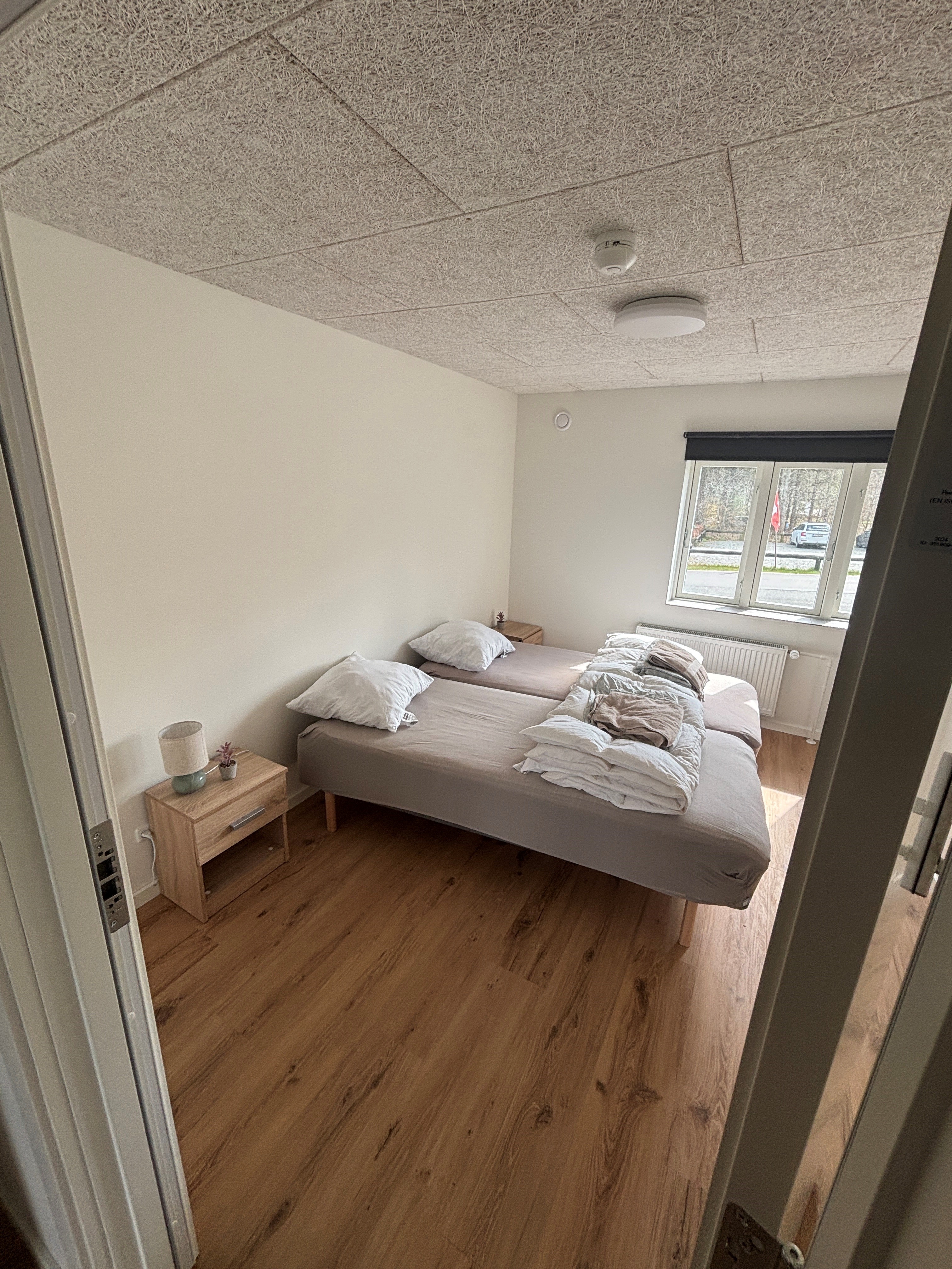 Eight shirts arranged on table in black, olive, grey, blue, white, red, mustard, and green.